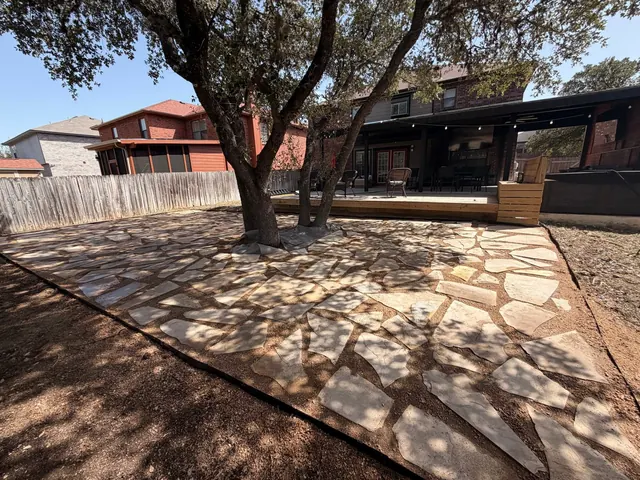 Flagstone patio with steel edging around an oak tree, with a new low deck and bench box behind
