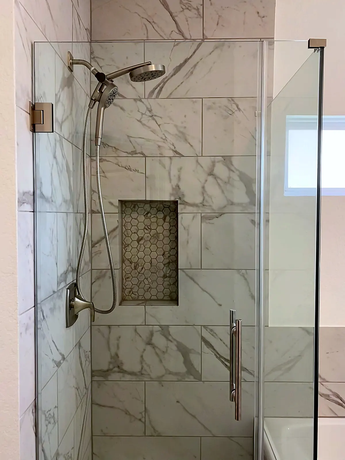 Marble look tile walk in shower niche