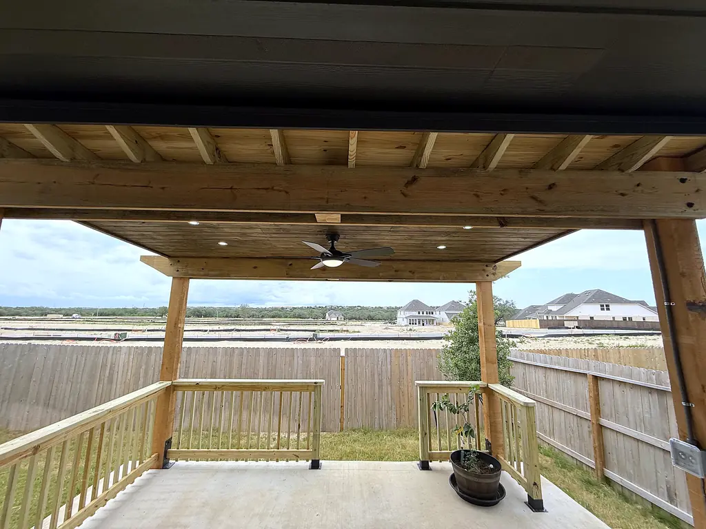 Stained wood patio cover with recessed lights, ceiling fan and new railing